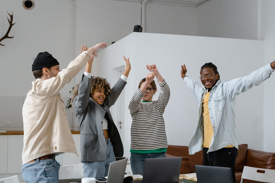 Group of diverse people working on laptops in a modern office space.